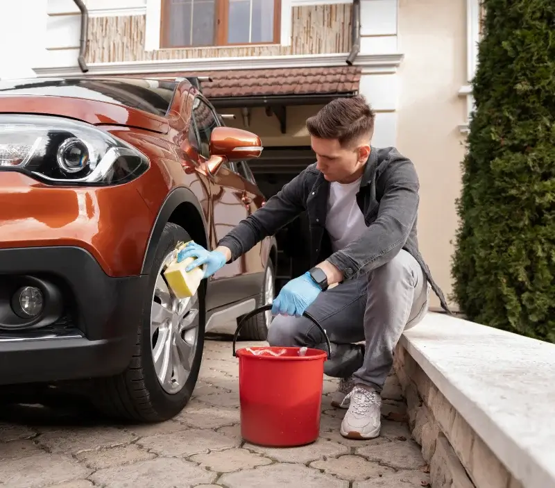 Lavage auto à domicile Le Grand-Village-Plage : professionnel intervenant sur un véhicule